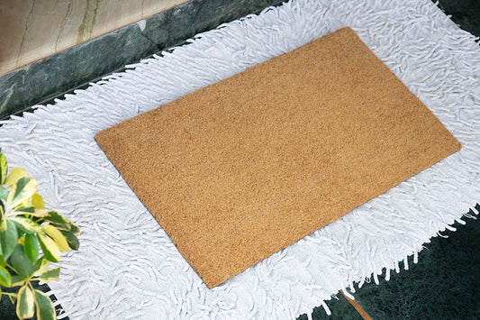 image of plain coir door mat over white jute cotton rug
